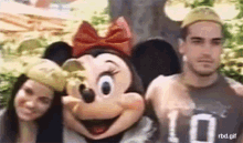 a man and a woman are posing with a minnie mouse costume