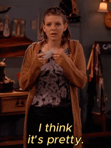 a woman wearing a tie dye top and a tan cardigan says i think it 's pretty