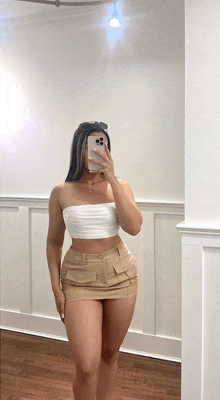 a woman taking a picture of herself in a mirror with her phone