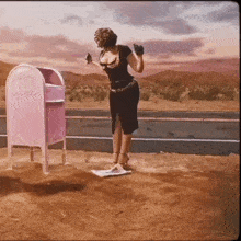 a woman is standing in front of a pink mailbox that says ' girly mail ' on it