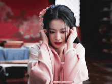 a woman in a pink kimono with a flower in her hair is being photographed by weibo by qinglingchu