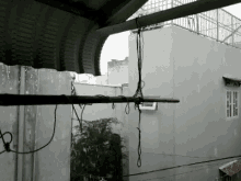 a building with a roof that is covered in rain and a fence with a rope hanging from it .