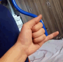 a person 's hand is making a thumbs up sign