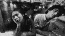 a man and a woman are sitting back to back at a table .