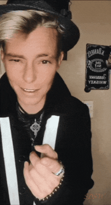 a man wearing a top hat stands in front of a sign that says jack daniel 's