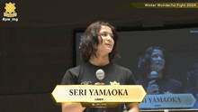 a person holding a microphone with the name seri yamaoka on the front