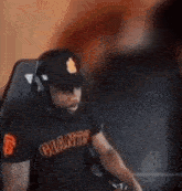 a man is sitting in a chair wearing a giants shirt and headphones .