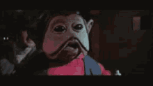 a close up of a monkey with a mustache and a red shirt