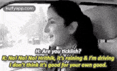 a woman is sitting in the driver 's seat of a car talking to another woman .