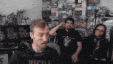 a man wearing a black shirt with the word dacula on it talks into a microphone