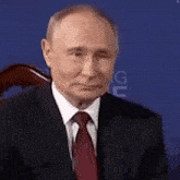 a man in a suit and tie is sitting in a chair .