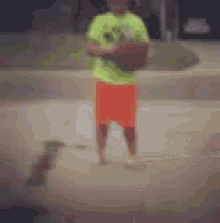 a man in a neon green shirt is holding a basketball .