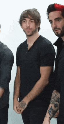 a man in a black shirt has a tattoo on his wrist