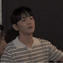 a man wearing a striped shirt is talking in korean
