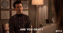 a man in a polka dot shirt is asking if he is okay