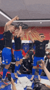 a group of soccer players are celebrating with a trophy