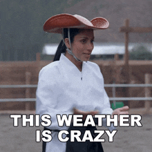 a woman wearing a cowboy hat with the words " this weather is crazy " above her