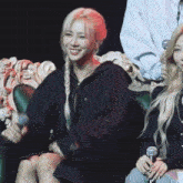a woman in a black jacket is smiling while sitting on a chair
