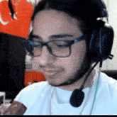 a man wearing glasses and headphones is eating a bar of chocolate