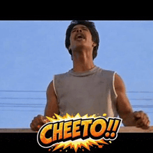 a man with a mustache is standing in front of a cheetos sign .