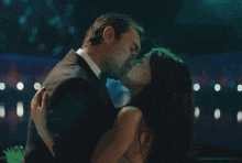 a man and a woman kissing in a dark room