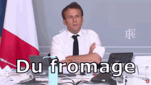a man sitting at a desk with his arms crossed and the words du fromage written on the bottom