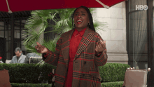 a woman singing in front of a red umbrella with hbo on the bottom