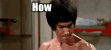 bruce lee is making a funny face while holding a sword in his hand .
