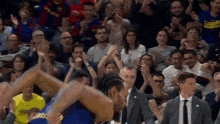 a basketball game is being played in front of a crowd wearing jerseys that say ' fc barcelona '