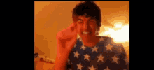 a man is wearing an american flag shirt and making a peace sign .