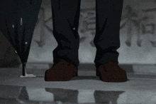 a person standing next to an umbrella with a reflection of their feet in the water