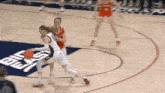 a basketball game is being played on a court with a coast logo on the floor