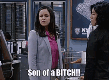 two women are standing next to each other in a room and one of them is saying `` son of a bitch '' .