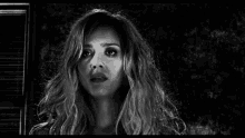 a black and white photo of a woman with curly hair