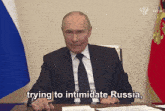 a man in a suit and tie is sitting at a desk and saying " trying to intimidate russia "