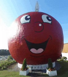 a giant red apple with a smiling face painted on it