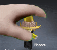 a hand is holding a toy that says ' picsart ' on the bottom