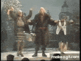 a group of people are dancing on a stage with their arms in the air .