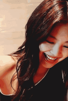 a close up of a woman 's face smiling with her mouth open
