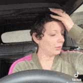 a woman in a car has a tattoo on her neck that says " heaven "