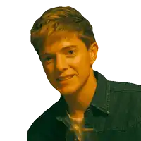 a young man wearing a denim jacket is smiling