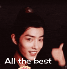 a man giving a thumbs up with the words " all the best " behind him