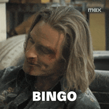 a man with long hair is smiling and the word bingo is above his head