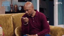 a man sitting on a couch with a cigarette in his hand and the words tyler perry 's house of payne above him