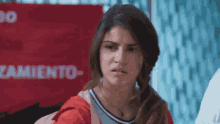 a girl is standing in front of a red sign that says " cambio "