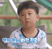 a young boy is sitting in a chair and making a face .
