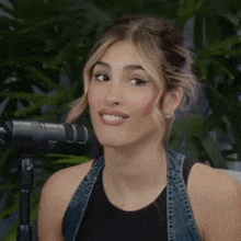 a woman is smiling in front of a microphone .