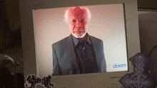 a man in a suit is displayed on a computer monitor with the word doom on it