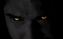 a close up of a person 's eyes with red eyes in the dark .