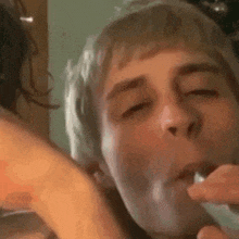 a close up of a person brushing another person 's teeth with a brush .
